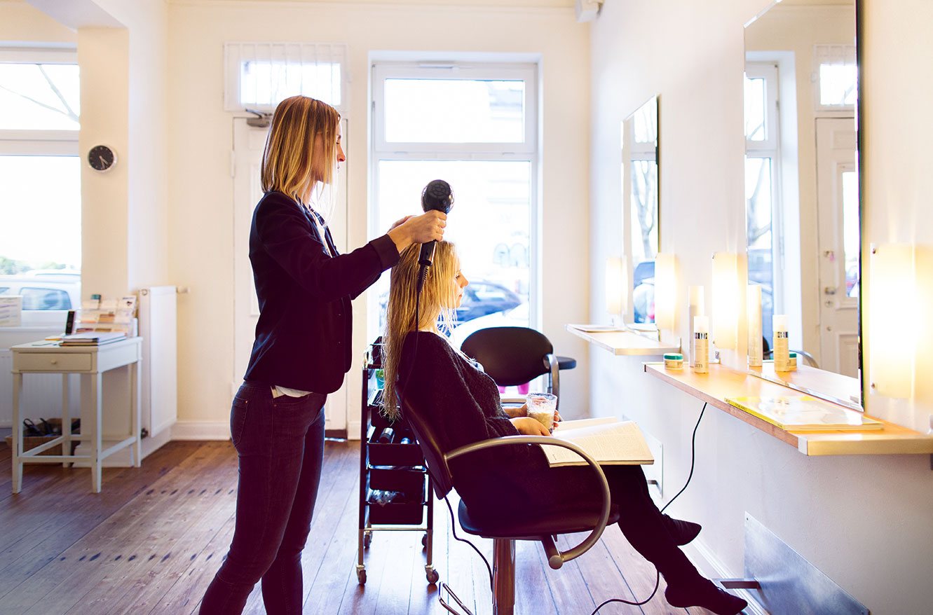 Nancy Riediger föhnt einer Kundin im Salon die Haare